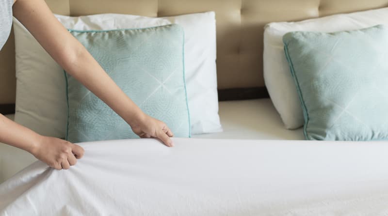 A housekeeper making the bed in a resident's suite