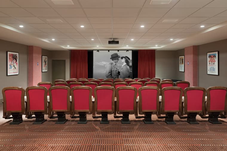 Amica London's theatre featuring red velvet seating and a Casablanca movie playing on the screen.
