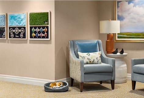 Hallway area shows textile art Textile art is hanging in a hallway alongside an inviting chair and lamp.