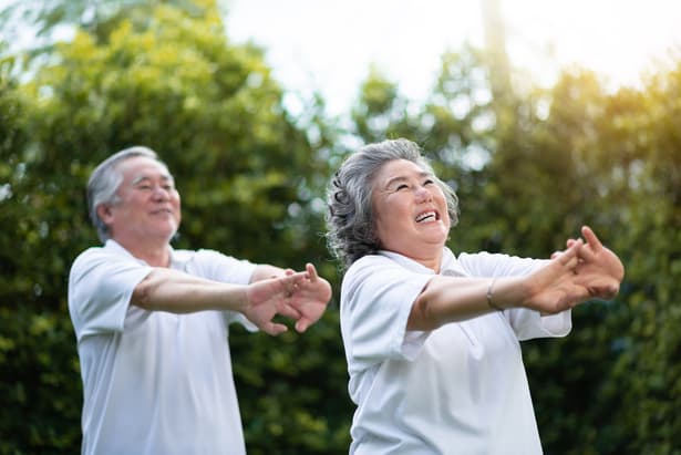 Asian couple stretching stock image of an asian couple stretch, tai chi together outside