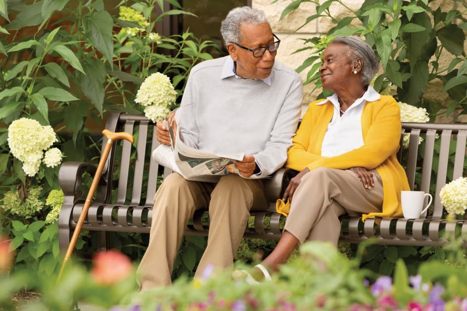 Senior couple sitting on a bench in a garden Senior couple sitting on a bench in a garden