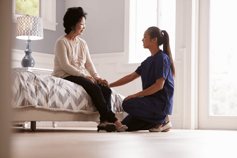 Senior Woman with Caretaker Stock image of Senior Asian woman on the bed with her caretaker
