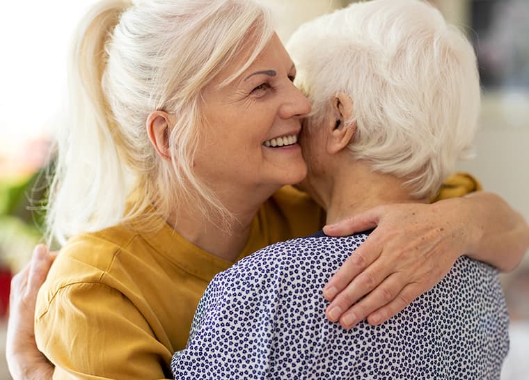 Alzheimer's National Event 2022 - Web Panel Image Mature woman embracing her senior mother outside.