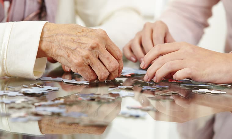 Hands with puzzle Image for Conversations Article Know common forms of dementia in seniors. Amica seniors playing puzzle.