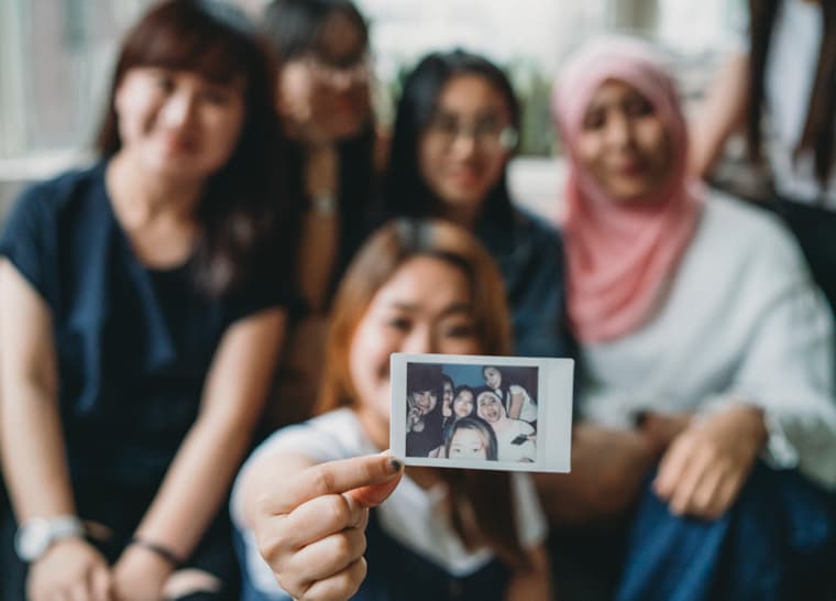 Equity Diversity and Inclusion Hero Banner Desktop Multiethnic group of friends showing an instant print to the camera