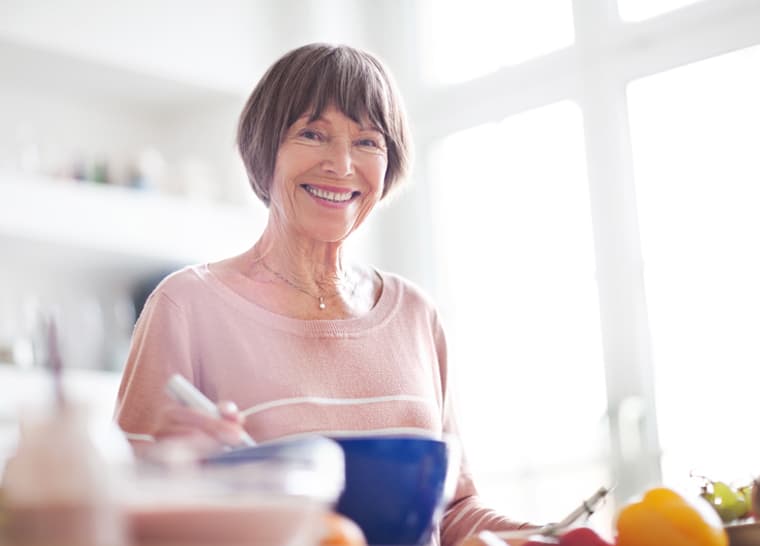 Amica Dietary Guide Panel Portrait of beautiful elderly woman in kitchen looking at camera smiling