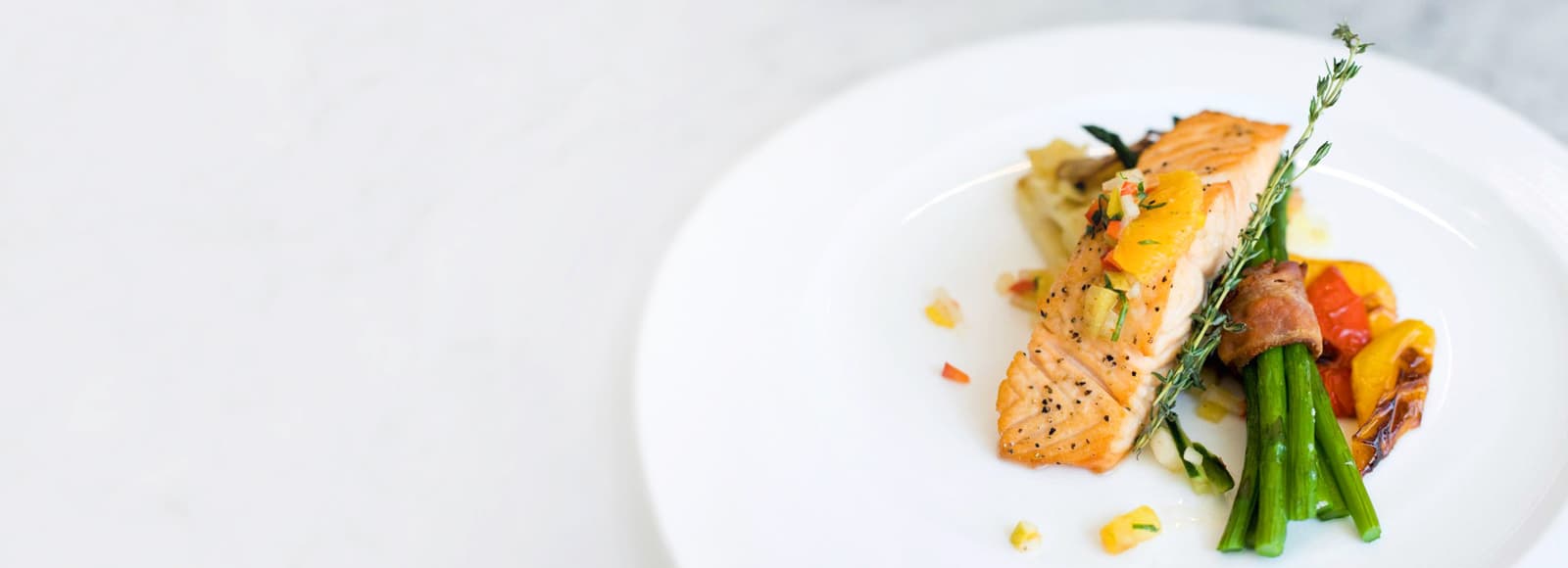 Amica Dining Panel Fade Right Dining photo with salmon and asparagus entree at Amica senior living residence.